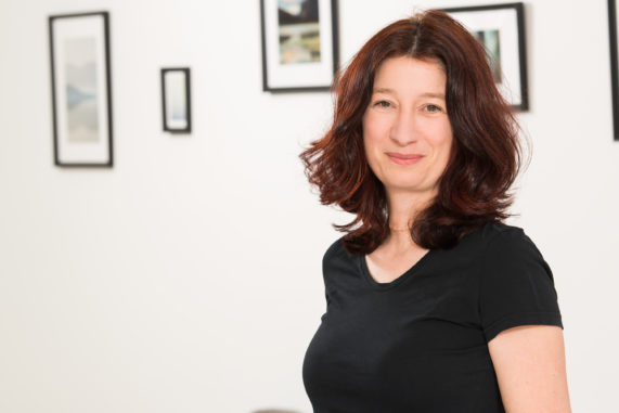 Mitarbeiterin Alexandra Bednarzyk mit rötlichen Haaren lächelt in die Kamera.